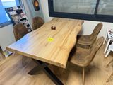 une table et des chaises en bois dans une pièce dotée d'une grande fenêtre