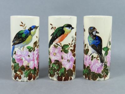 three vases with birds painted on them sitting on a table