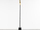 a black and gold floor lamp with a cross on top