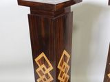two wooden pedestals with designs on them on a white background