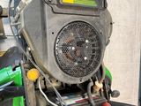 a close up of a green tractor with a fan on it