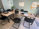 a table with chairs and a laptop on it in a room