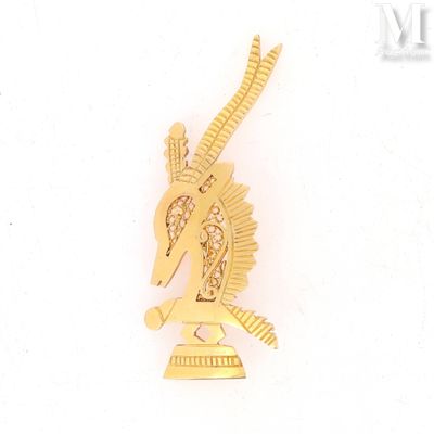 a gold colored brooch with a bird on top of it