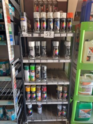 many cans of paint on the shelves in the store