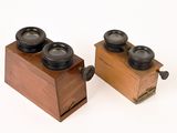 two wooden boxes with camera lenses on them on a white surface