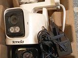 a white camera in a box with wires and a charger