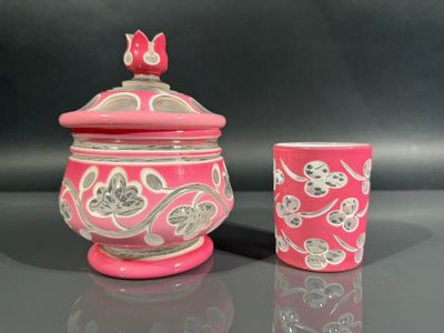 a pink and white vase and a cup on a table