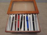 many pens in a wooden box on the floor