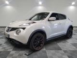 the white nissan juke suv is parked on a checkered floor