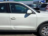 a white car parked in a parking lot with other cars