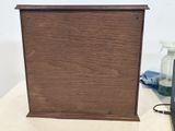 a small wooden box with a clock on top of it