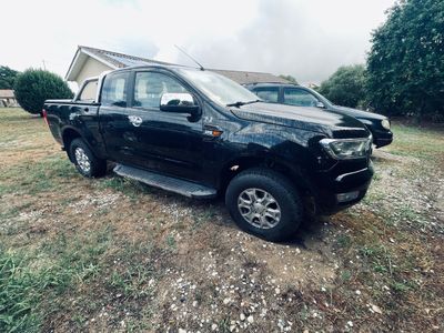 une photo d'un pick-up noir garé dans un champ
