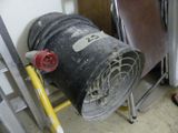 a large metal barrel sitting on a stand next to a chair