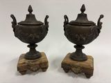 paire d'urnes anciennes en bronze reposant sur des socles en bois