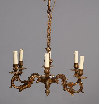 un lustre ancien en laiton à cinq bougies, muni d'une chaîne