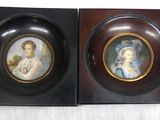 two framed pictures of women in formal dress sitting on a table