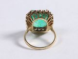 a close up of a ring with a green stone in it