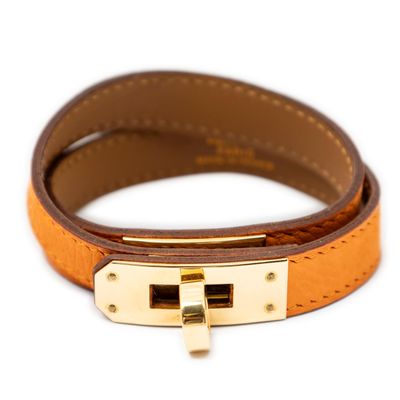 the bracelet is made of brown leather and has a gold clasp