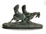 a statue of two birds that are running on the ground