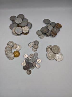 a lot of silver and gold coins on the table