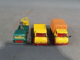 three toy trucks sitting next to each other on a table