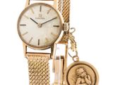 une photo d'une montre-bracelet pour femme sur laquelle repose une pièce de monnaie