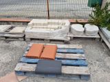 a pile of bricks on a pallet next to a fence