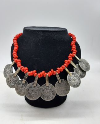 un collier composé de perles de corail rouge et de pièces d'argent
