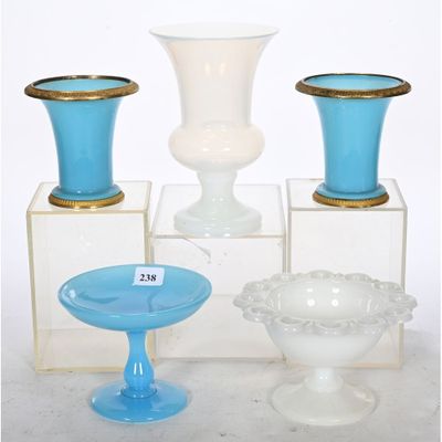 several vases and bowls are sitting on display on a white surface