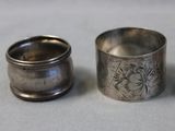 two silver napkin rings sitting next to each other on a table