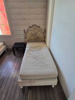 un petit lit dans un coin d'une pièce, près d'une fenêtre