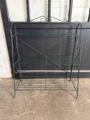 a metal rack with a shelf on it in front of a door