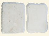 two pieces of white pottery sitting on a table
