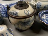 several blue and white porcelain teapots and bowls on a table