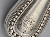 a silver spoon with a design on it sitting on a table