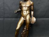 a bronze statue of a man holding a ball and a dog