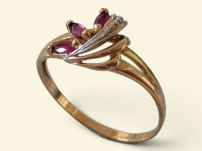 Gros plan sur une bague en or ornée de pierres roses