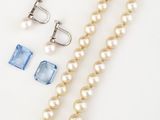 un gros plan sur un collier de perles et une paire de boucles d'oreilles