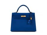 a blue leather handbag with a gold lock on the handle