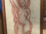 dessin représentant une femme nue, encadré dans un cadre en bois posé sur une table