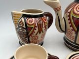 a tea pot and a cup on a plate