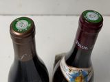 two bottles of wine sitting next to each other on a table