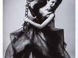 black and white photograph of a woman in a dress holding a guitar