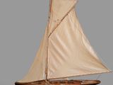 a model of a sailboat on a wooden stand