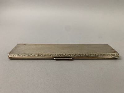 un étui à cigarettes en argent posé sur une table