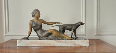 une statue représentant une femme et un chien assis sur une table