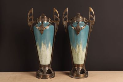 two vases sitting on a table with a black background