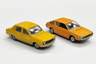 deux voitures jouets assises l'une à côté de l'autre sur une surface blanche