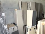 several refrigerators and freezers are stacked up in a room