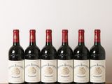 six bouteilles de vin rouge alignées sur une table en bois